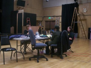 From left, staqe manager Cyndi Baumgardner, director Maggie Larrick, and costume designer Amanda discuss technical and staging issues to be worked out after the first tech rehearsal - Nov. 21, 2011